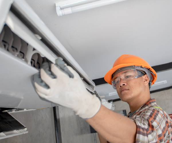 Technician Mainitaining an HVAC Unit in Tennessee 