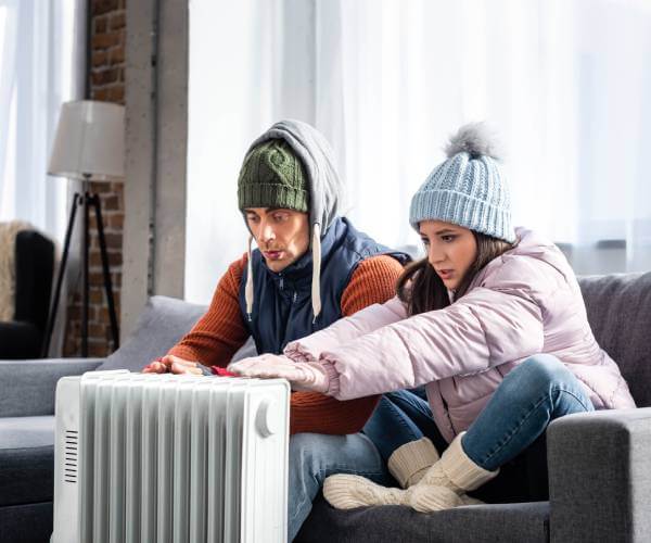 People huddled around malfunctioning heater