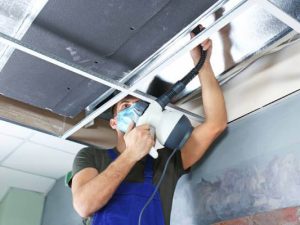 Residential technician performing an air duct cleaning