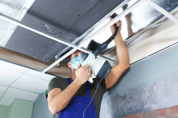Residential technician performing an air duct cleaning