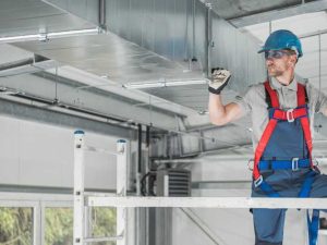 H V A C Technician performing maintenance on air ducts