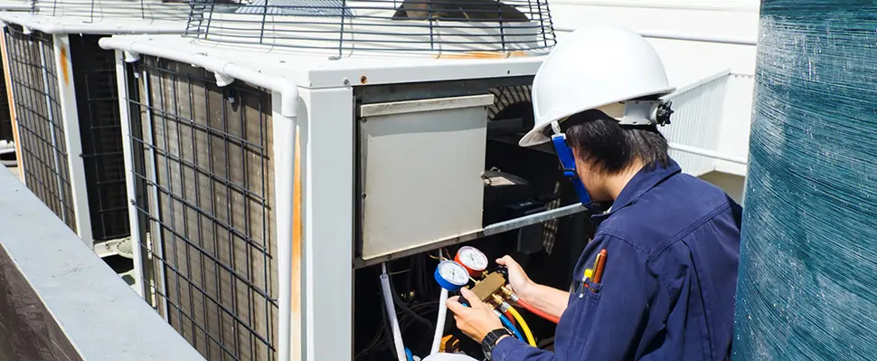 Technician reading gauges on AC Unit